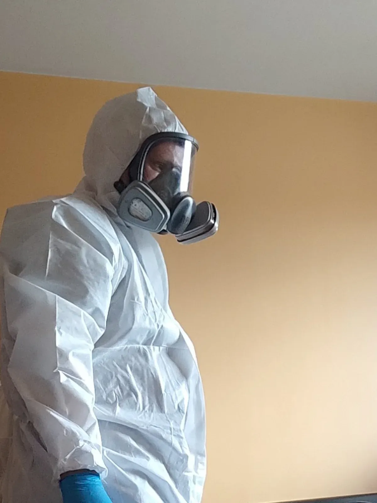 Technicien Certibiocide en combinaison et masque respiratoire lors d'un traitement punaises de lit
