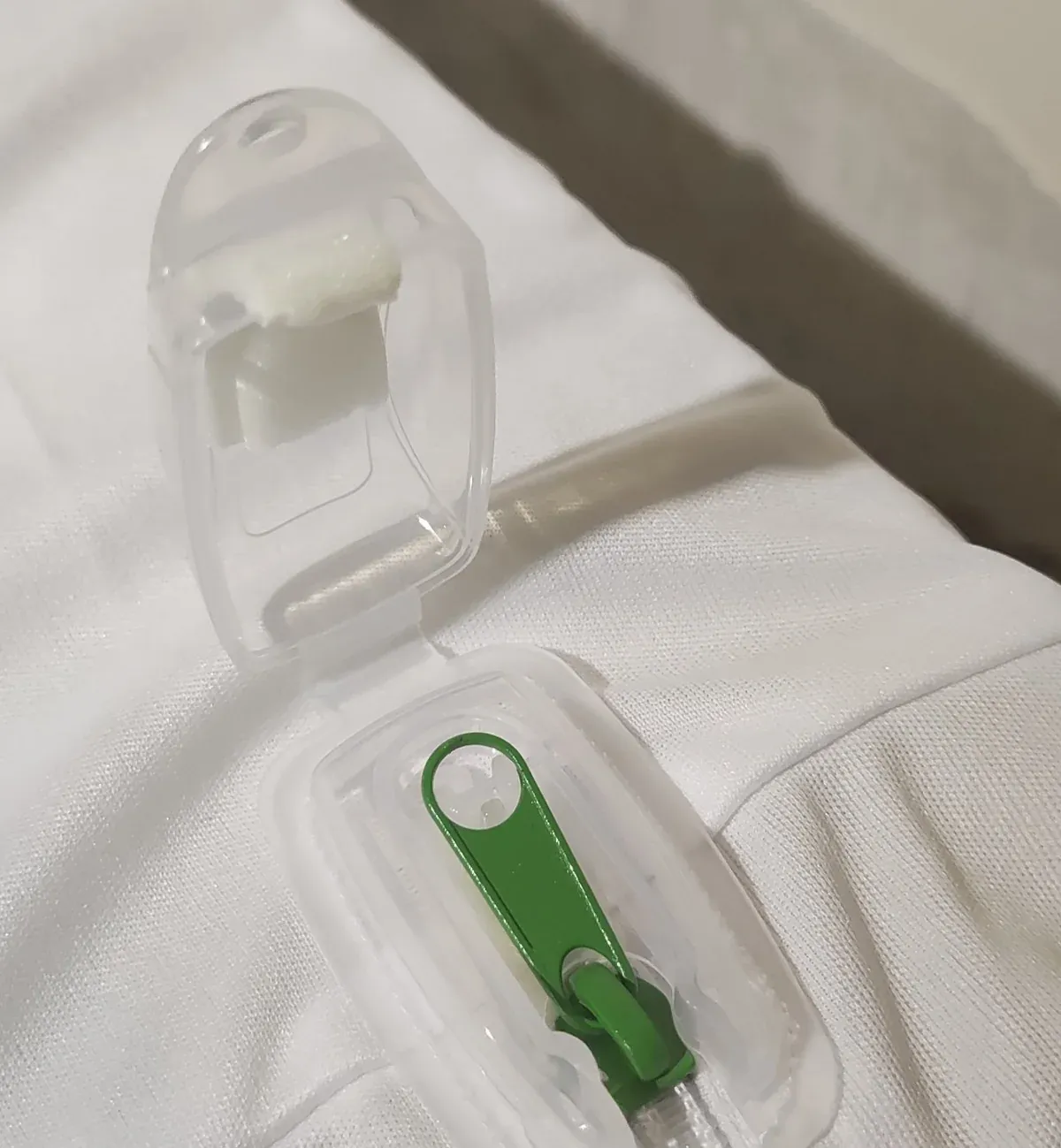 Boîtier Zip-N-Click ouvert, curseur vert visible à l'extrémité de la fermeture